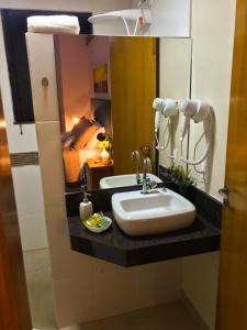 特雷斯科拉松伊斯Pousada Divina Minas的一间带水槽和镜子的浴室