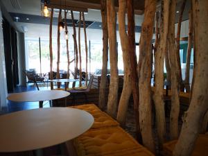 居让梅斯特拉ibis Styles Arcachon Gujan Mestras的一间设有桌椅和树木的餐厅