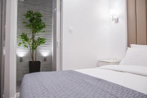 韦里亚Veria Luxury Suite的一间卧室配有一张床和盆栽植物