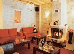 埃拉蒂特里卡隆米克里阿托斯酒店的客厅配有橙色沙发和壁炉