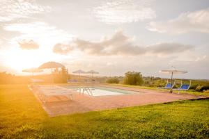 蒙塔约内卡斯特拉瑞迪同德托斯卡纳乡村度假酒店及Spa中心的草坪上带椅子和遮阳伞的游泳池