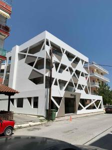 帕拉利亚卡泰里尼斯Villa Hara Suites的街道边的白色大建筑