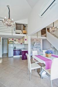 赫瓦尔Island Hvar Seaside Villa Levanda with Beach, Pool & Seaview的一间用餐室,配有一张紫色的桌子和白色的椅子