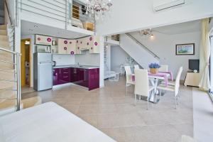 赫瓦尔Island Hvar Seaside Villa Levanda with Beach, Pool & Seaview的厨房以及带紫色橱柜和桌子的用餐室。