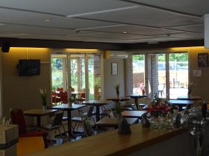 布鲁日布鲁日超值住宿宾馆的用餐室设有桌椅和窗户。