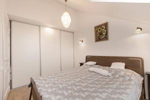 考纳斯Misko Apartaments的卧室配有一张带白色墙壁的大床