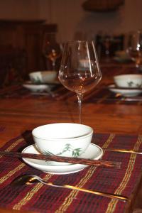 Thái BìnhThai Binh Garden的一张桌子,上面放着碗和一杯葡萄酒