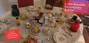 沙勒维尔-梅济耶尔La Ferme De Saint Julien的桌子,带桌布的桌子,带盘子和杯子