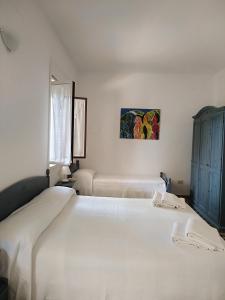 阿雷内拉拉维德尔玛雷住宿加早餐旅馆的一间白色卧室,配有两张床和墙上的绘画