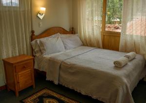 乌鲁班巴Eco Lodge Los Perales-Urubamba的一间卧室配有一张带木制床头板的床和窗户。