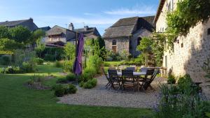 La Bastide-lʼÉvêqueChambres d’hôtes du Presbytère的花园内带桌椅的庭院