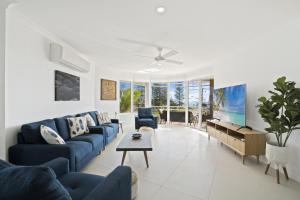 黄金海岸基拉棕榈假日公寓的客厅配有蓝色的沙发和桌子