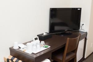 大阪Lantana Osaka的客房设有书桌、电视和椅子