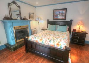 尤里卡斯普林斯Hidden Springs Bed and Breakfast的一间卧室设有一张床和一个壁炉