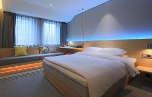 杭州忆泊酒店（杭州西湖店）的一间卧室配有一张大床和一张沙发