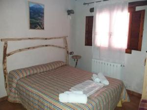 内尔皮奥Casa rural Tio Juan的一间卧室配有一张床,上面有两条毛巾