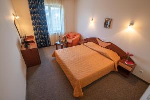 瓦尔纳阿达莫酒店的一间小卧室,配有一张床和一把椅子