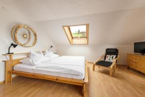 施瓦岑贝格WÄLDERHAUS Apartments的一间卧室配有一张带镜子和椅子的床