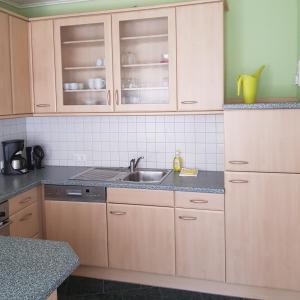 格雷沃斯米伦Ferienwohnung in Ostseenähe的一个带木制橱柜和水槽的厨房