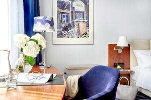 莱比锡莱比锡海滨公园酒店的一间卧室配有书桌、蓝椅和床。