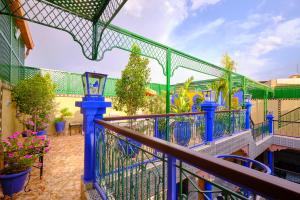 马拉喀什中央宫殿酒店的阳台设有蓝色的围栏和鲜花。