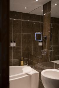 皮耶塔尔萨里Hotel Epoque & Apartments的带浴缸和盥洗盆的浴室