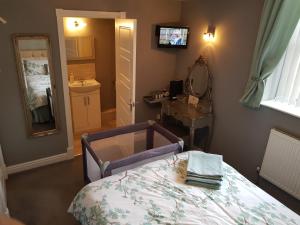 诺丁汉Chatterley House的一间卧室配有床、水槽和镜子