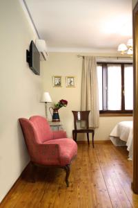 巴伦西亚德东胡安Hostal El Palacio的客厅配有红色椅子和一张床