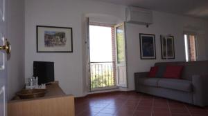 里奥马里纳Trilocale a Capo d'Arco Vista Mare的带沙发和窗户的客厅