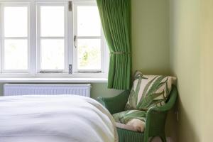 莱明斯特The Hayloft, Wall End Farm的卧室配有一张床和一把椅子,靠窗