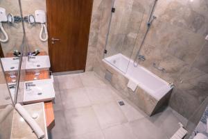 萨拉热窝拉顿广场酒店的带淋浴、浴缸和盥洗盆的浴室