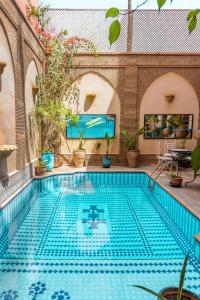 马拉喀什Amani Hotel Suites & Spa的游泳池,位于带游泳池的建筑内