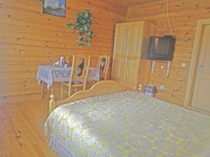 KryžkalnisPas Medžiotoją Motelis的一间卧室配有一张床、一张桌子和一台电视。