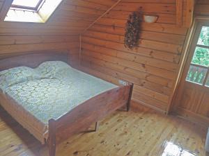 KryžkalnisPas Medžiotoją Motelis的木制客房内的一间卧室,配有一张床