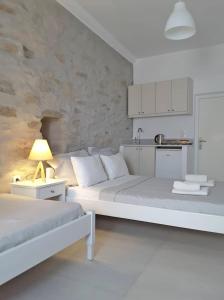 洛加拉斯Klironomos Apartments Logaras的白色客房 - 带两张床和厨房