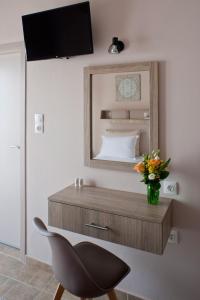 纳乌萨Liprando的一间卧室配有带镜子和椅子的梳妆台