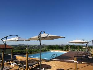 科斯蒂廖莱达斯蒂拉吉比安娜B&B酒店的一个带遮阳伞和椅子的游泳池以及一个游泳池