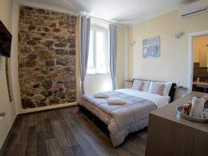 斯培西亚Vicolocorto Affittacamere的一间卧室设有一张床和石墙