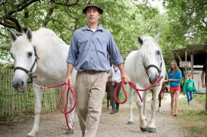 洛特河畔的维伦纽夫莱斯胡谷特斯酒店的走上一条小径的两匹白马的男人