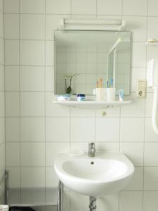 Klein ZickerUns Gartenhus的白色的浴室设有水槽和镜子