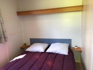 Jau-Dignac-et-LoiracLE MEDOC AUX 4 VENTS的一张床上有两个枕头的房间