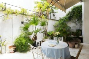 罗马Trastevere Designer Terrace Apartment的种有植物的庭院里摆放着桌椅