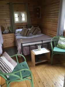 泰恩河畔纽卡斯尔West Wood Yurts Ltd的一间卧室配有一张床、两把椅子和一张桌子