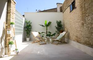 潘普洛纳El Oasis de la Estafeta的一座带椅子和植物的庭院