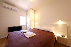 扎达尔Pyrotima Apartments的一间卧室配有一张床,上面有两条毛巾
