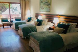 迈滕西约玛贝拉度假酒店的酒店客房,配有三张带绿床单的床
