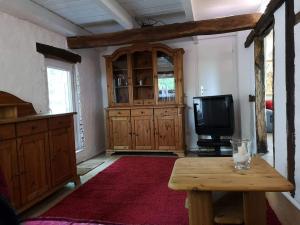 哈姆Ferienwohnung Hamm Rhynern im alten Bauernhaus 1870的客厅配有电视和木桌。