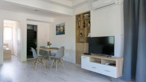 特雷比涅Apartments Ena的客厅配有电视和桌椅