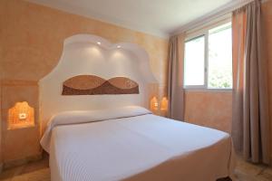 维琪奥港Résidence Domaine De Caranella公寓 的卧室配有白色的床和床头板