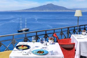 索伦托安巴夏托理大酒店的一张桌子,上面放着两盘食物,享有海景
